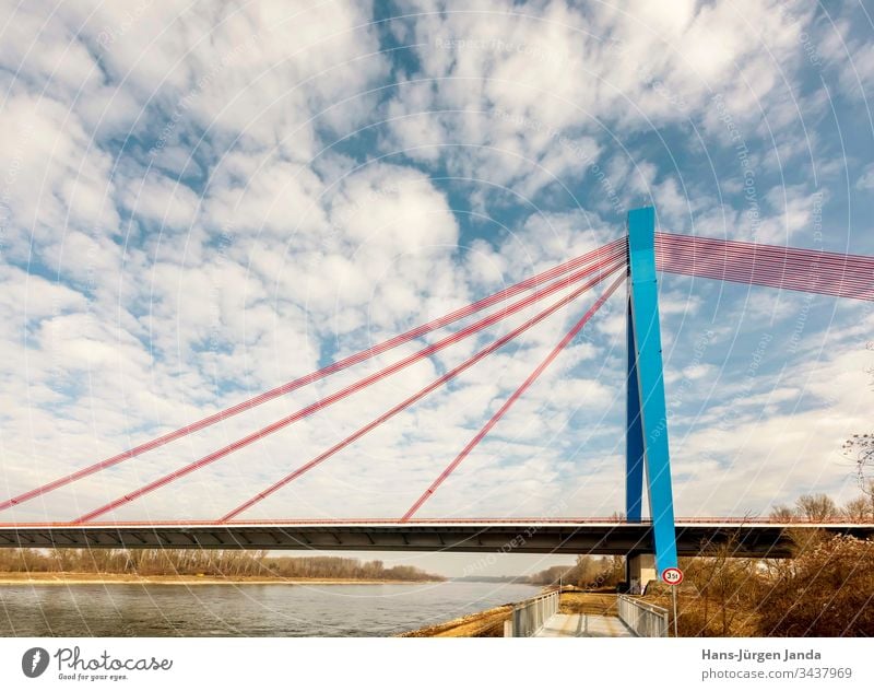 Suspension bridge over a river with blue sky Highway Bridge Brook Beach cars transfer Street River piers bank Clouds Transport Sky Manmade structures Blue