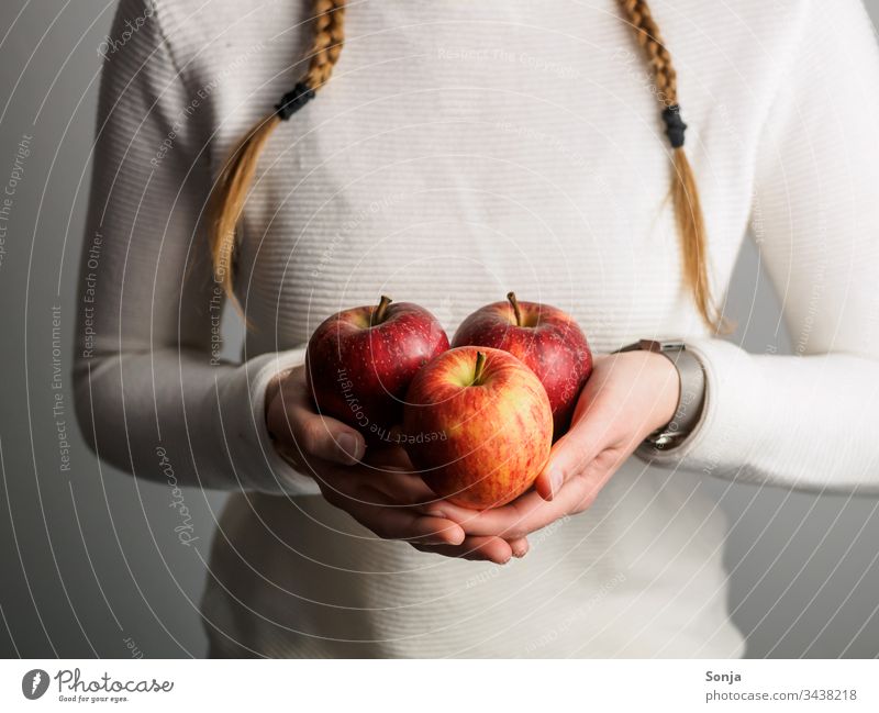 Young girl with braids holds red apples in her hands Decompose by hand stop plaits Plaited Healthy Eating fruit Food photograph Vitamin Fresh Vegetarian diet