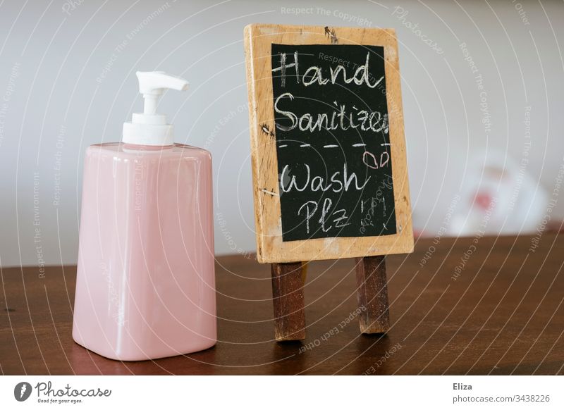 A dispenser of disinfectant with a sign asking you to disinfect your hands to reduce the risk of infection with coronavirus disinfectants disinfect sb./sth.