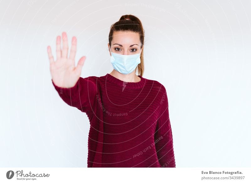 caucasian woman indoors wearing protective mask. Making a stop sign with hand. corona virus concept covid-19 coronavirus home stay home adult infection medicine