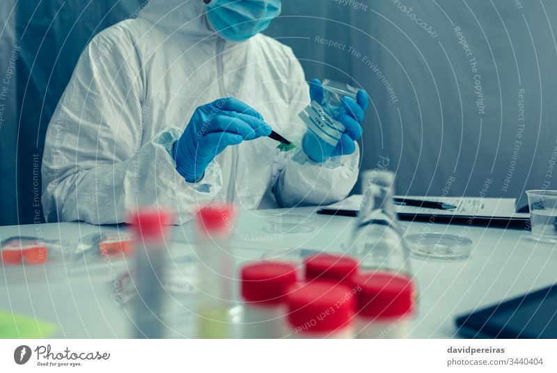 Scientist with protection suit doing research in the laboratory scientist analyzing sample virus coronavirus protection gloves scientific research cure