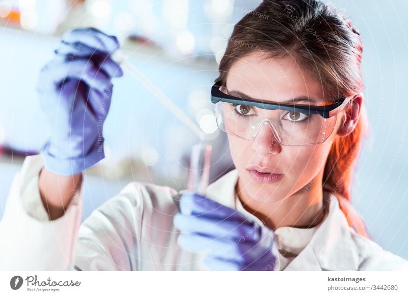 Female researcher pipetting solution into test tube in life science laboratory. woman scientist technology analysis experiment analyzing biotechnology