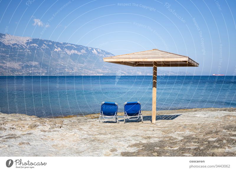 Hammock and umbrella on a rocky beach in Kefalonia, Greece amandakis beautiful blue calm chair coast coastal coastline concept greece hammock holiday idyllic