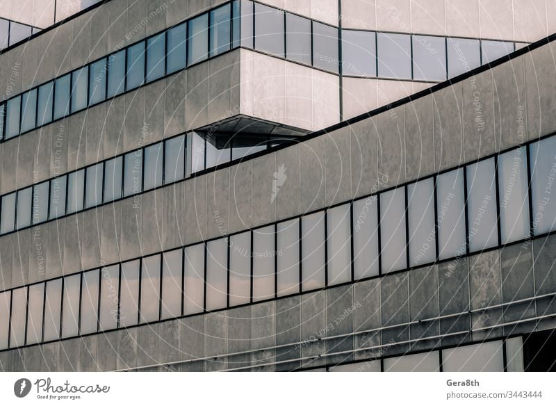 gray high concrete building with reflection of the sky and clouds in the windows abstract architecture background blue business city empty floor house large