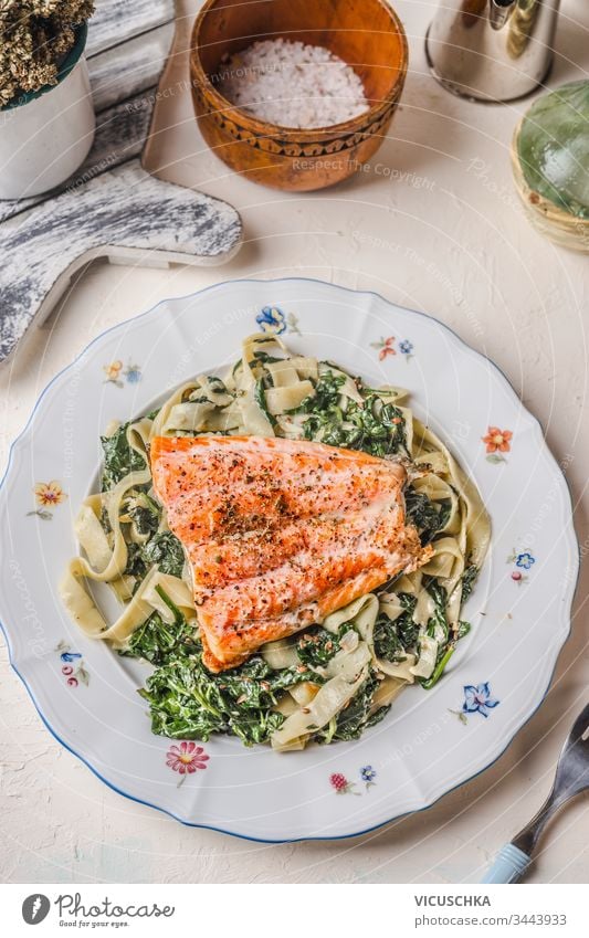 Plate with noodles, salmon and spinach on white rustic table background. Healthy food meal. Dieting. Lunch. Top view plate healthy dieting lunch top view tasty