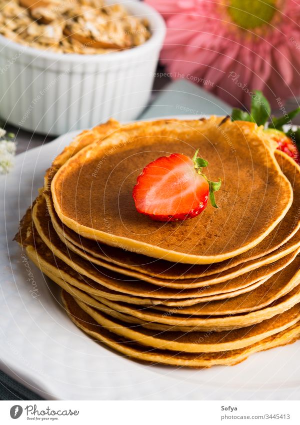 Stack of oatmeal pancakes with strawberries healthy strawberry stack summer spring cook flower breakfast morning flour syrup maple dish plate white table