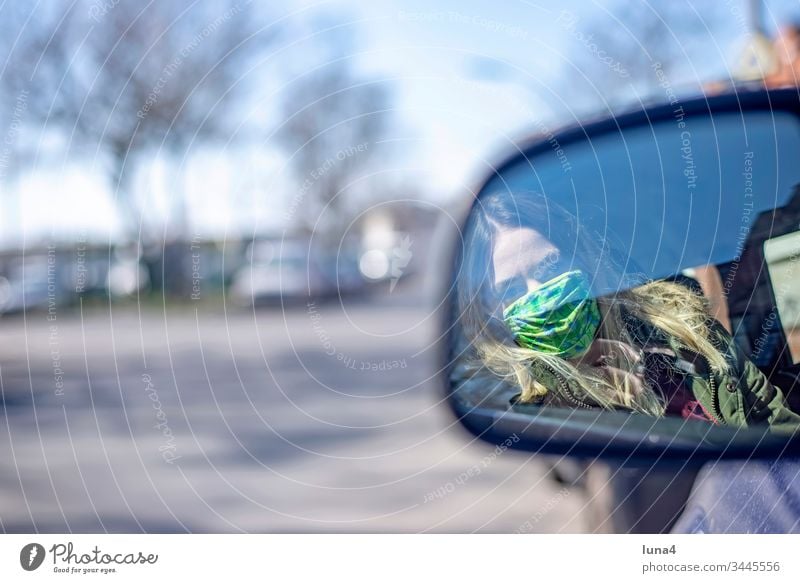 Young woman with mouth guard sitting in the car Woman Mask Rear view mirror Mirror Meditative Driving Respirator mask Car Face mask Town Virus coronavirus