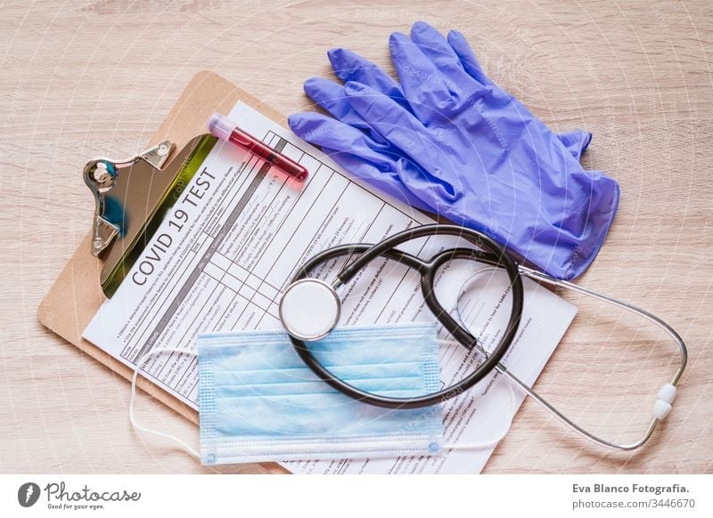 top view of a doctor workspace with protective gloves, protective mask, stethoscope, blood tube and coronavirus test. Covid-19 concept corona virus covid-19