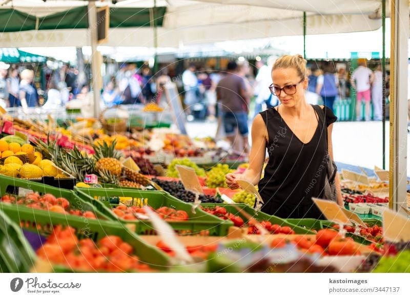 Woman buying fruits and vegetables at local food market. Market stall with variety of organic vegetable woman shopping vegetarian grocery fresh nutrition choice