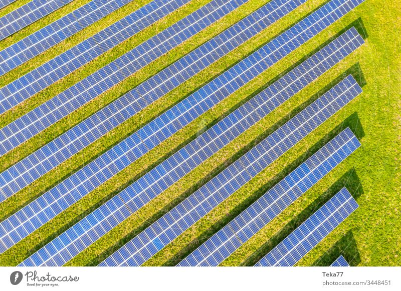 a modern solar cell park from above solar cells sun sun rays sun beams blue white hot yellow grass meadow green clouds reflections lithium modern solar cells