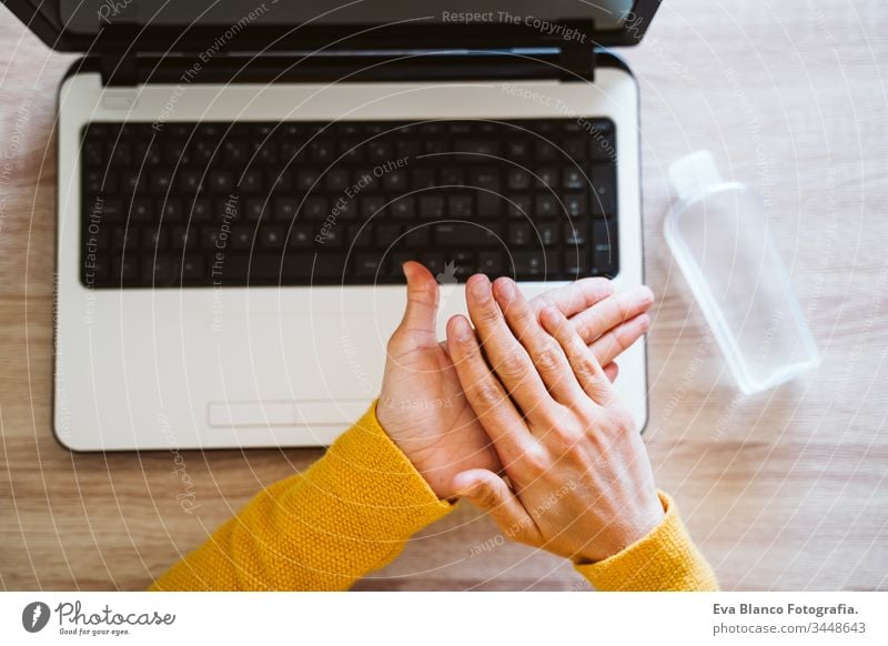 young woman working on laptop at home, using hand sanitizer alcohol gel. Stay home during coronavirus covid-2019 concept disinfectant hands antibacterial