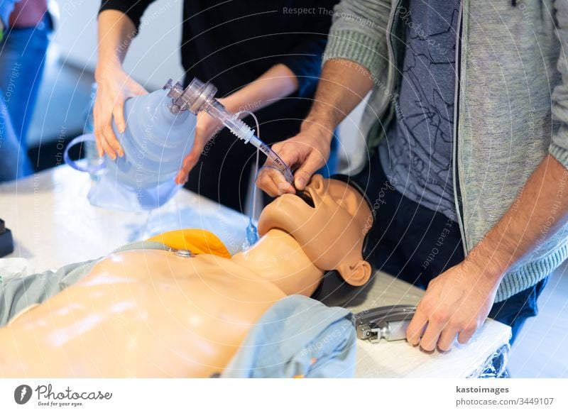 Medical doctor specialist expert displaying method of patient intubation on hands on medical education training and workshop. Participants learning new medical procedures and techniques.