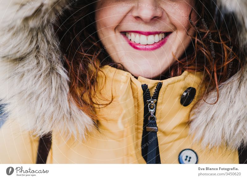 portrait of young beautiful woman wearing a hood smiling outdoors. Happiness and lifestyle unrecognizable yellow coat happiness city urban street smile happy
