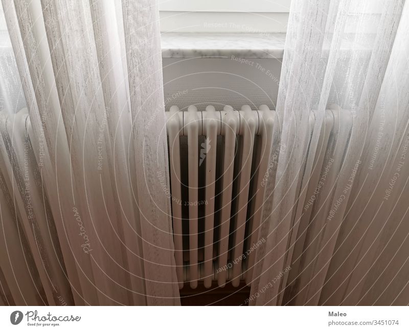The central heating radiator is covered with light white curtains house room interior background window bland airy architectural architecture bright building