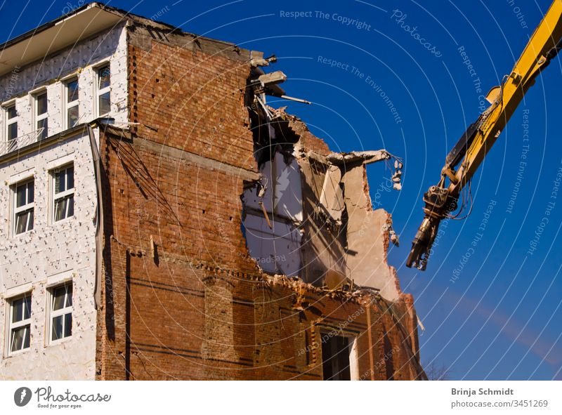 Demolition of a building with a crane against a blue sky Profession City Building owners Old House (Residential Structure) aborting Crush Exterior Architecture