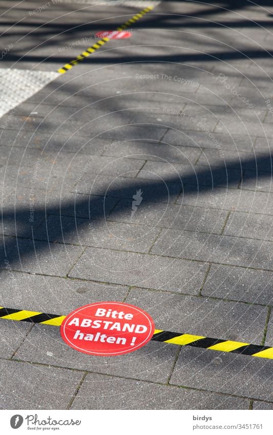Distance markings in front of a supermarket. Customers are asked to keep their distance because of the risk of infection by the coronavirus. Covid 19