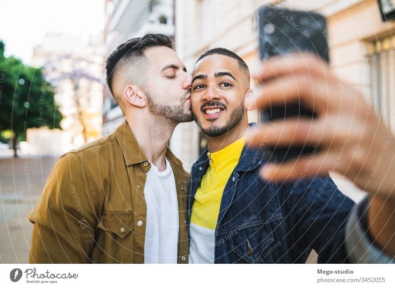 Gay couple taking a selfie in the street. gay love relationship mobile phone date lovely partnership positive city freedom life young pride dating looking