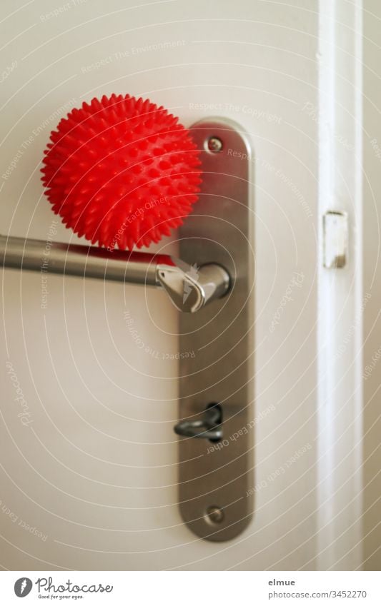 red ball as a symbol for corona virus lies on a door handle coronavirus covid-19 Infection risk of contagion lubricant infection transfer Virus flu Illness Clue