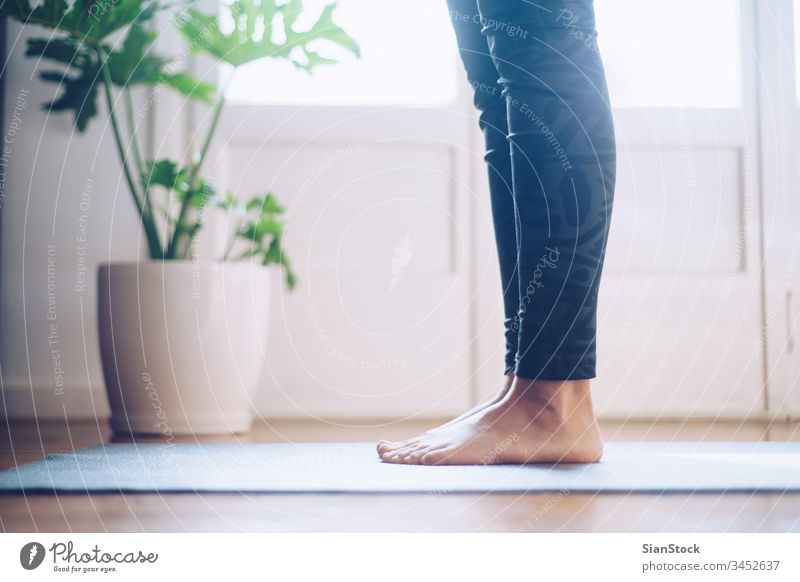 Barefoot woman stretching on pilates ladder barrel Stock Photo by