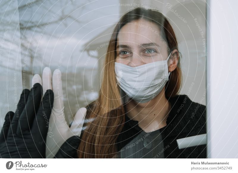 happy woman seeing her fried who came to visit her due to coronavirus covid-19 wit mask and gloves on window at home social distancing adult cage china concept