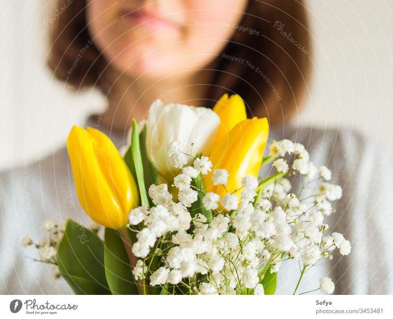 Woman holding bouquet of tulips. Woman's day flower bunch mother woman give spring easter hands floral white yellow lady march gift invitation greeting card