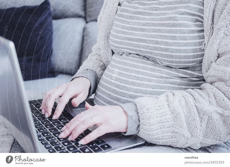 Young pregnant woman working at home with her laptop belly computer quarantine pregnancy motherhood wifi progress work at home information casual comfort
