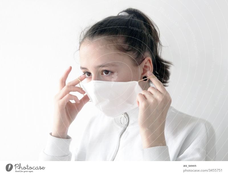 Girl puts on face mask Respiratory protection Respirator mask Mask Human being Colour photo 1 Fear Protection Threat Dangerous Illness coronavirus