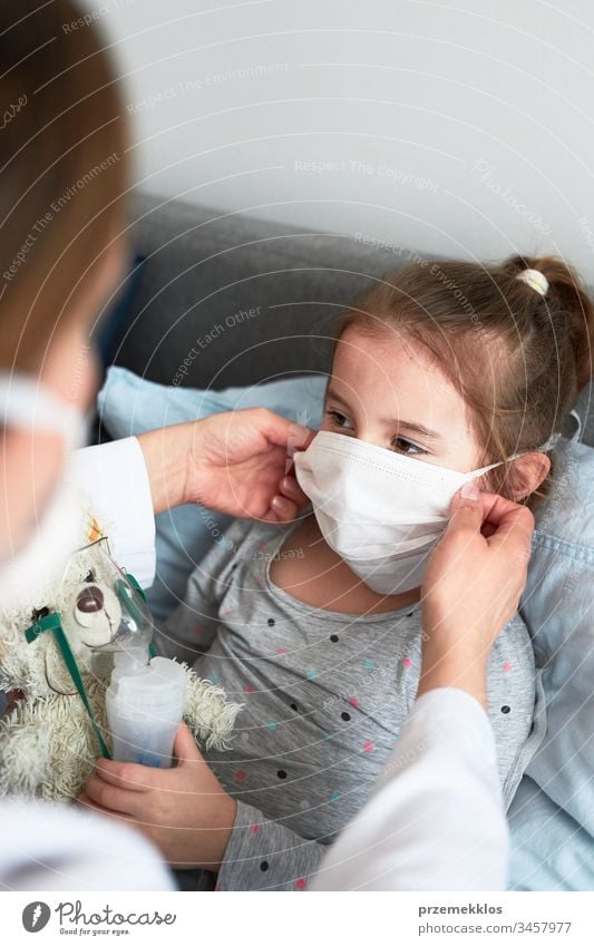 Doctor covering little patient's face with mask. Sick girl having medical inhalation treatment with nebuliser child virus infection doctor flu ill sick cold