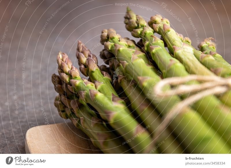 A bunch of green asparagus on a wooden board Asparagus Vegetable Food Nutrition Vegetarian diet Healthy Eating Organic produce Green Fresh Deserted Close-up