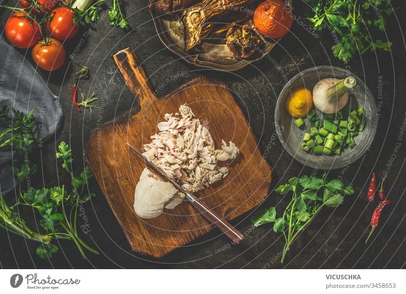 Pork kotelett with fresh ingredients for cooking - herbs,spices and  tomatoes. Vintage kitchen tools - fork and meat knife. Rustic wooden  backgound, top view, frame Stock Photo