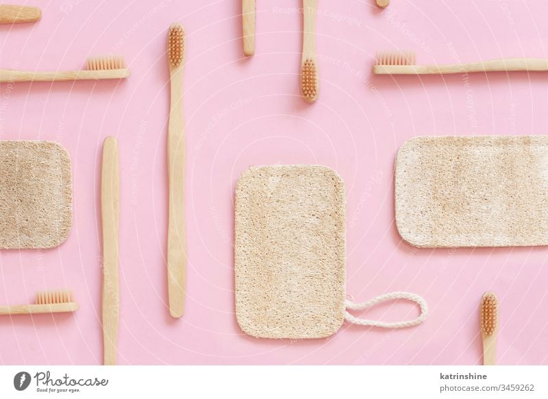 Eco friendly bamboo toothbrushes and dish washing sponges on pink background waste concept light pink top view zero waste Loofah tooth brushes eco health