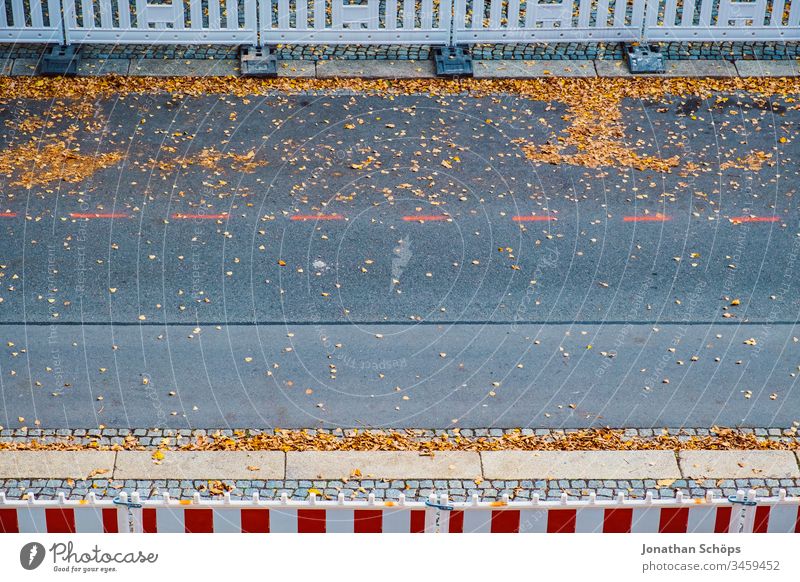 Top view on street in autumn with roadwork safety fence Autumn Minimalism Park Street Urban asphalt background image barrier bird's eye view construction