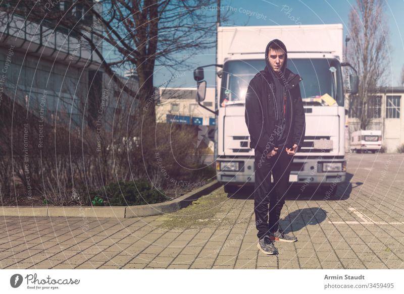 young man with backpack stands in front of a truck teenager lifestyle lorry portrait aeria architecture beautiful black boy building casual caucasian confident
