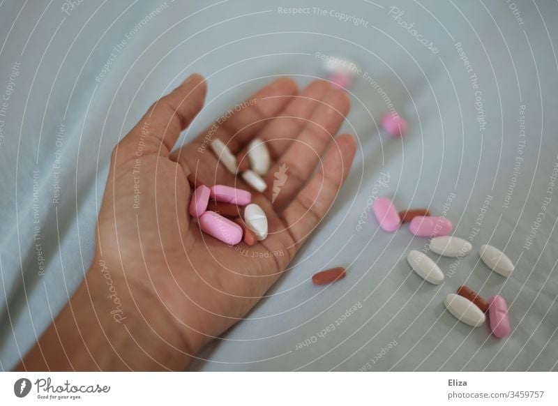 A hand in which several different colored tablets are lying; addiction problems, drug abuse, suicide drugs pills variegated Addiction Dependence Medication Pill