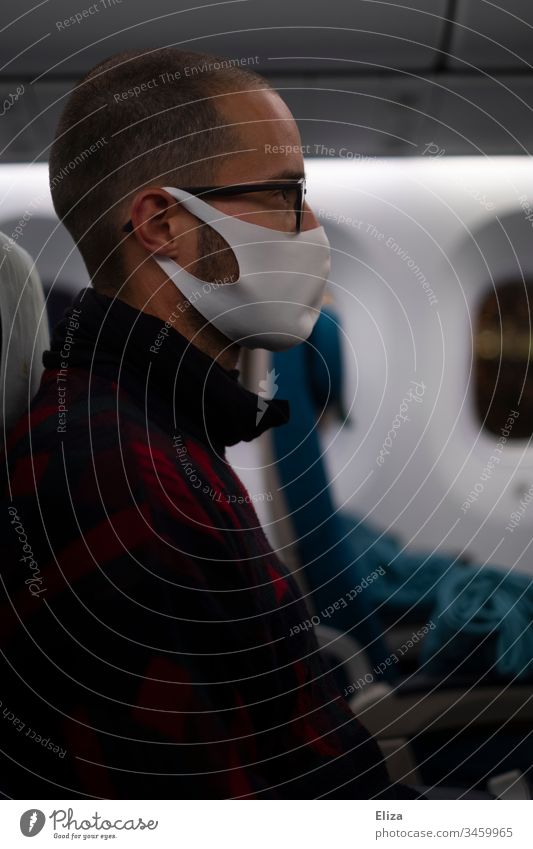 Man sitting in a plane with a face mask during the Corona Pandemic Airplane corona pandemic Face mask Mask fabric mask coronavirus prevention Virus COVID