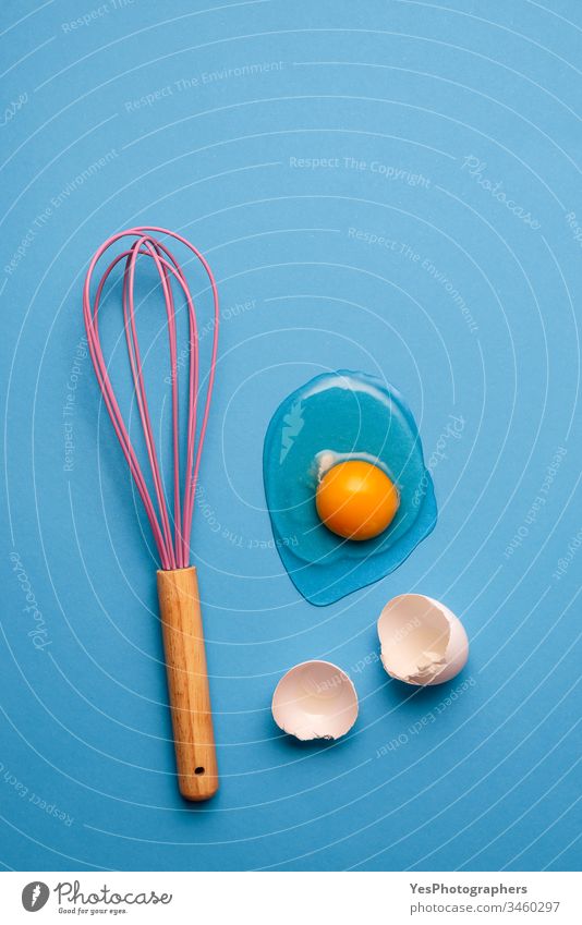 Cracked egg and whisk as a baking concept. blue clean colorful cooking cracked egg egg yolk eggshells flat lay food healthy eating home baking homemade