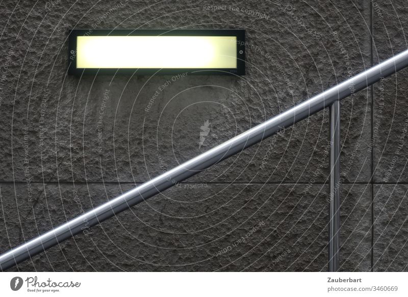Modern handrail leads upwards, in front of structured concrete slab and rectangular luminaire Handrail Stairs Wall (building) Concrete Wall (barrier) slabs