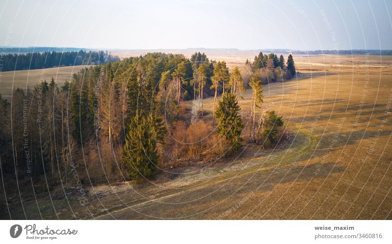 Sunny March-April evening scene. Calm spring countryside sunset Panorama aerial field agriculture cultivated plowed rural industrial sunny wood forest pine
