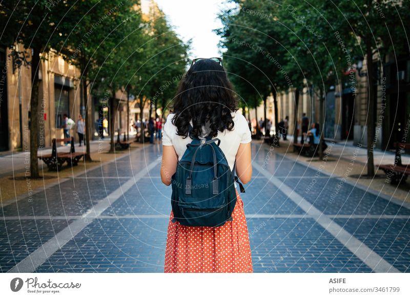 Tourist woman travelling alone tourist vacation girl holiday city happy backpack summer spring people rear view back view brunette Europe map lifestyle street