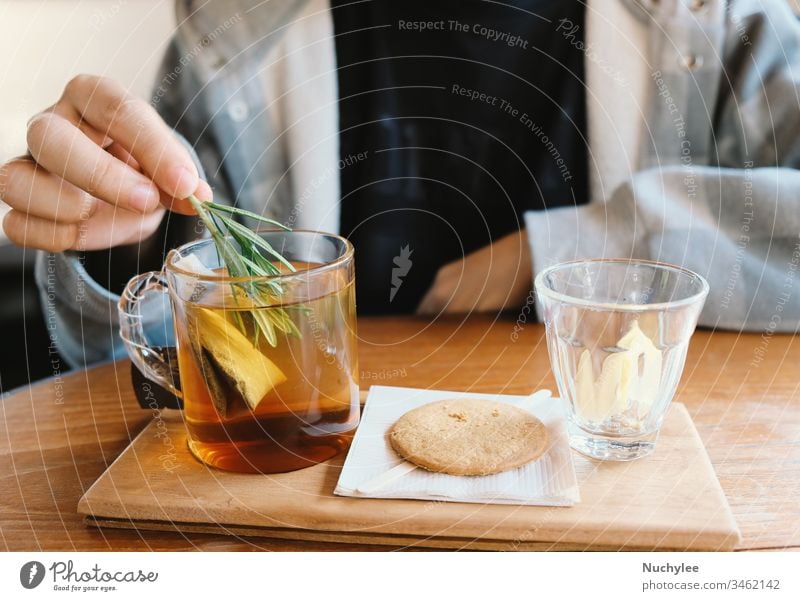 Close up young man hand putting rosemary into the hot tea for afternoon tea time break, relaxing and cozy at home aromatic asian background beverage bowl