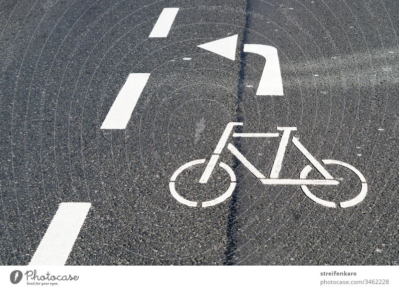 Cyclists please turn left through the gap, the white arrow of the road marking meant Street Traffic lane Road marking Lane markings White Gray Asphalt Cycling
