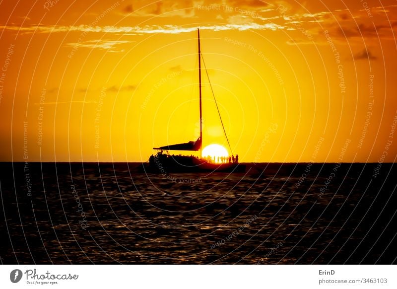 Sunset Sail with Sun Dropping Below Horizon and Boat sunset sky ocean sea water light color colorful twilight beauty beautiful silhouette boat horizon seascape