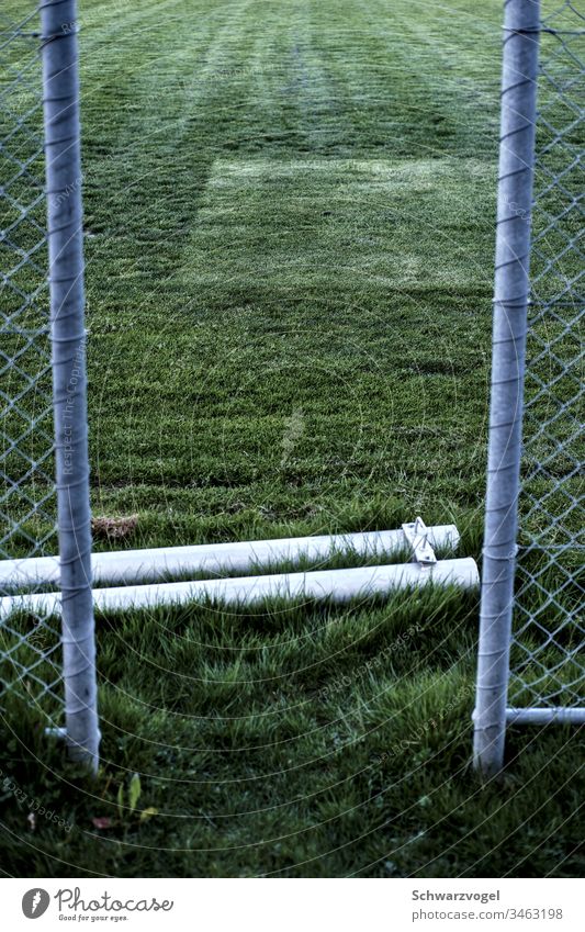 Access to a grass field Sports facility Lawn Lanes & trails Fence Gap in the fence Pole Pattern Green Tracks Meadow Grass Sporting grounds soccer field