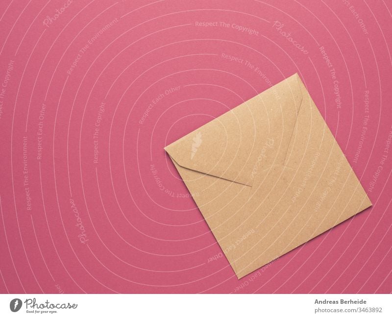 An envelope made from recycled paper on a red background with copy space isolated letter mail blank white post message communication correspondence card open