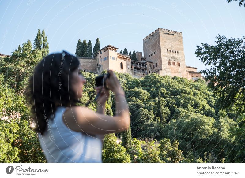 Woman tourist taking pictures in La Alhambra, Granada, Spain woman la alhambra camera tourism blurred person one person women outdoors granada andalusia spain