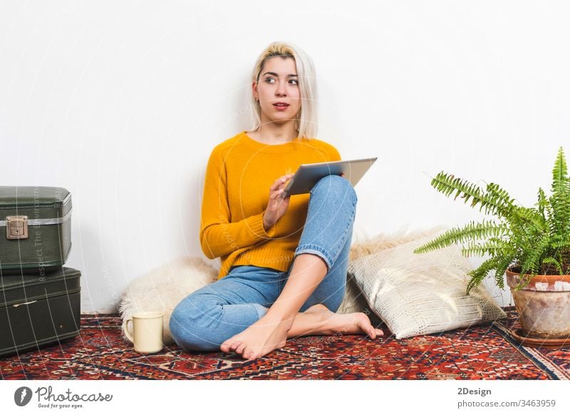 Young woman using tablet computer while sitting on floor at home. 1 young beautiful adult happy technology people cyberspace female digital person girl white