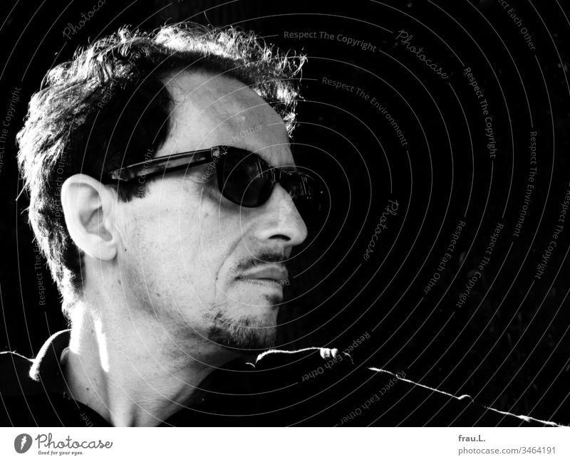 Through his distinctive sunglasses, the striking man looked strikingly into the distance. Man Human being Portrait photograph Black & white photo Facial hair