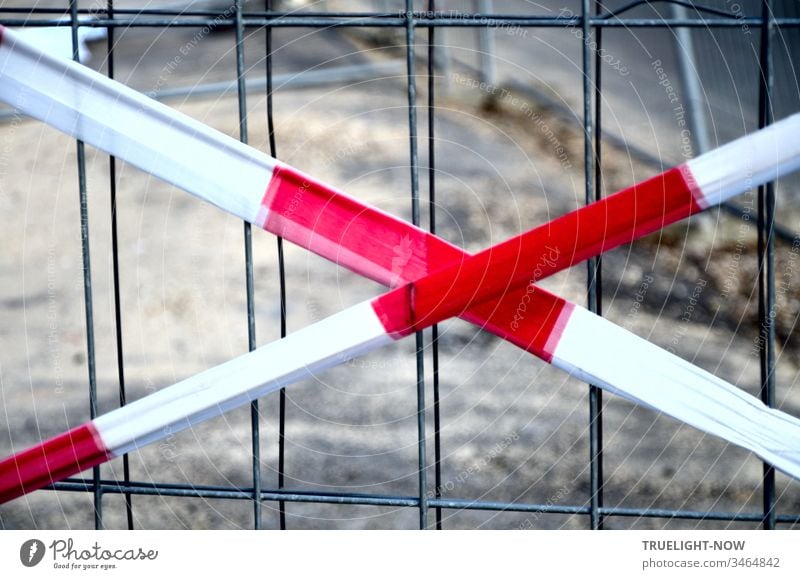 Not an X for a U but a warning made of red and white fluttering tape that points to a grid of thin wire mesh and says: Stop! Here we cannot continue because of a construction site.