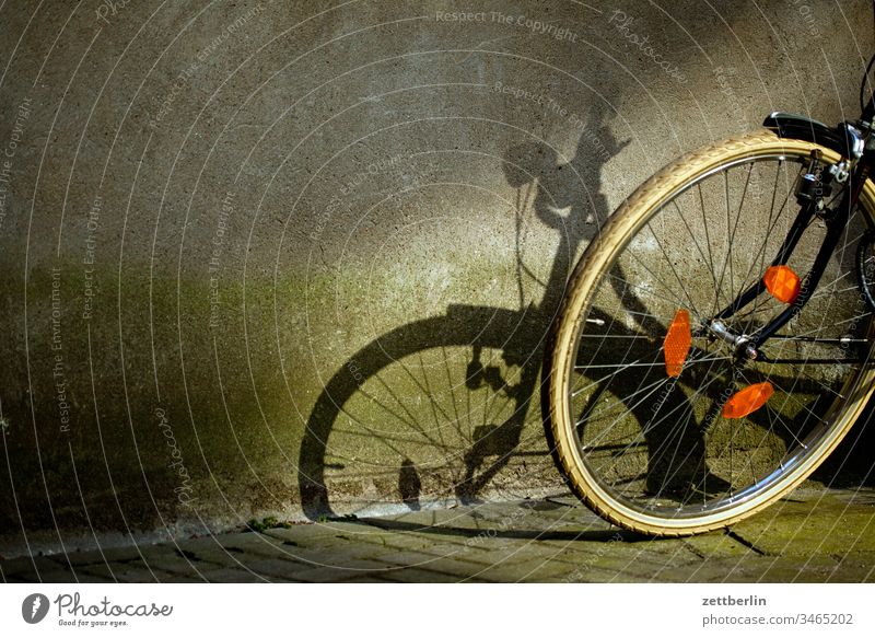 Shadow from the bike turned off Parking area Bicycle Backyard Courtyard Light Wheel Front wheel Sun Means of transport Sports Wait Parking lot Bicycle rack Tire