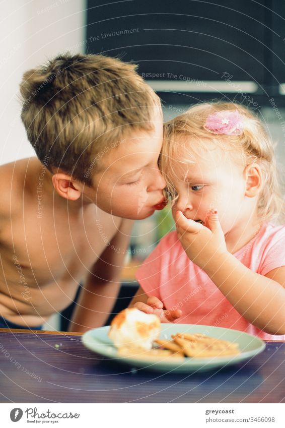 He always taking care of little sister and loves her very much. Brothers kiss for girl during the breakfast children cheek brother siblings boy morning meal kid